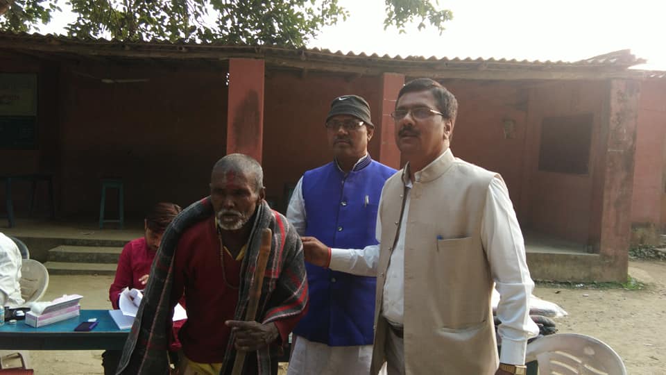 Dr. Binod Kumar Singh with an elderly villager at a Mahavir Singh Memorial Trust outreach in Madhubani